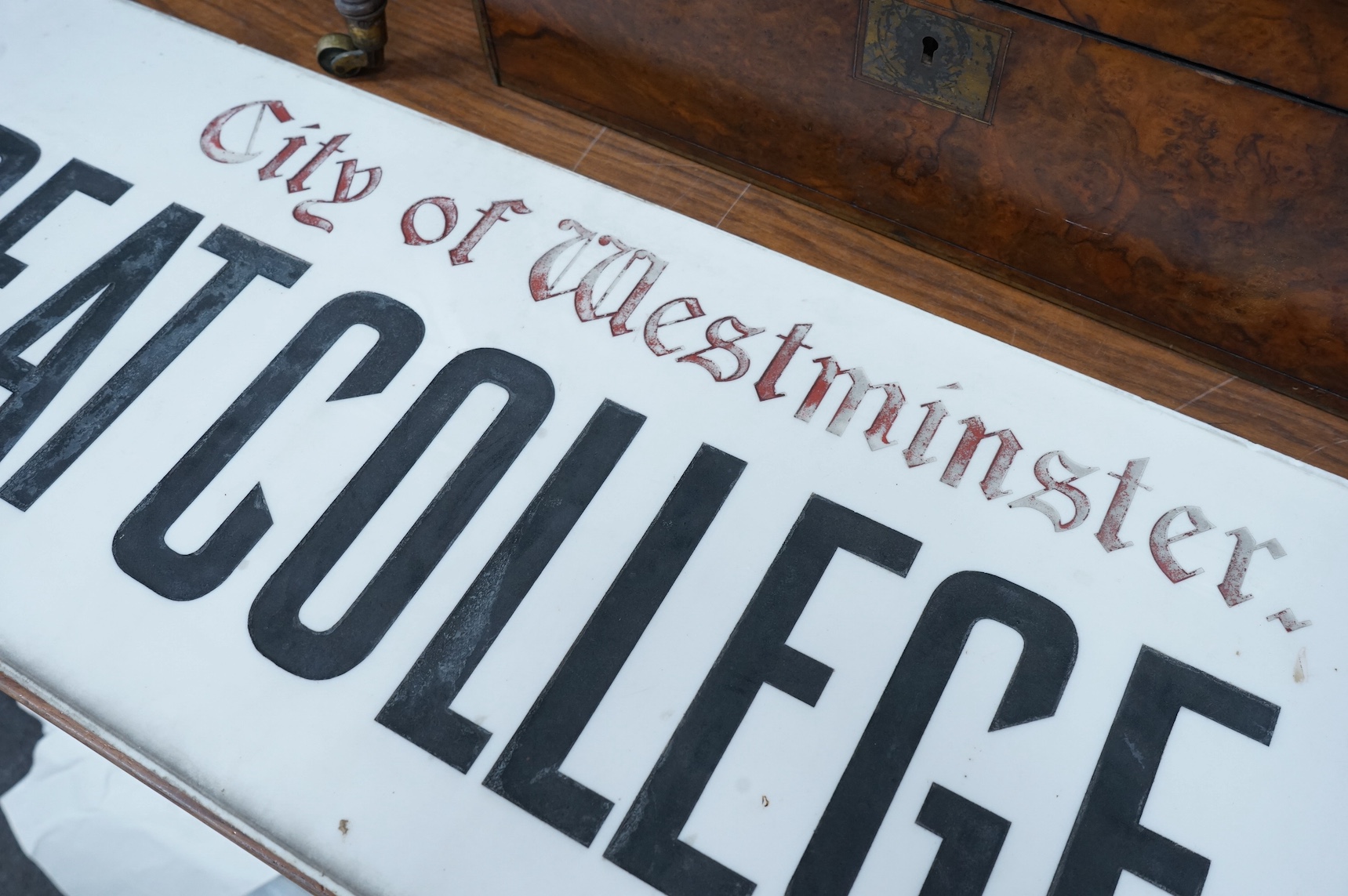 An early 20th century Vitrolite milk glass street sign, The City of Westminster, Great College Street, 30 x 91cm. Condition - chipped